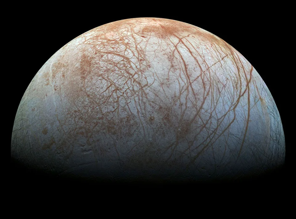 Dark branching fractures cross Europa's pale icy surface, interrupted by disrupted patches.