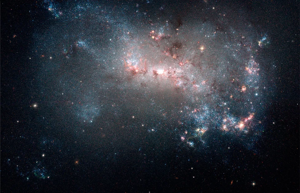 NGC 4449 contains a patchwork of stars and glowing gas without a symmetric spiral pattern.